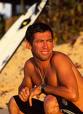 Foto do surfista Fbio Fabuloso, sentado na areia da praia